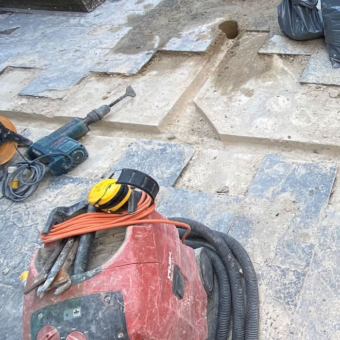 contractors creating chasing channels for wires in a london patio
